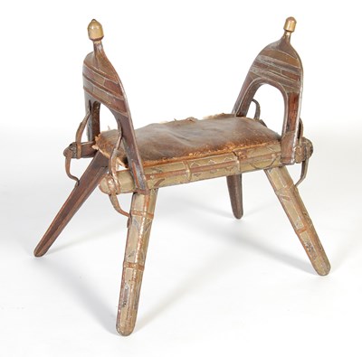 Lot 48 - A Persian white metal mounted dark wood 'camel' type stool