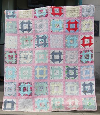 Lot 184 - A late 19th / early 20th century pink ground patchwork quilt