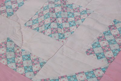 Lot 184 - A late 19th / early 20th century pink ground patchwork quilt