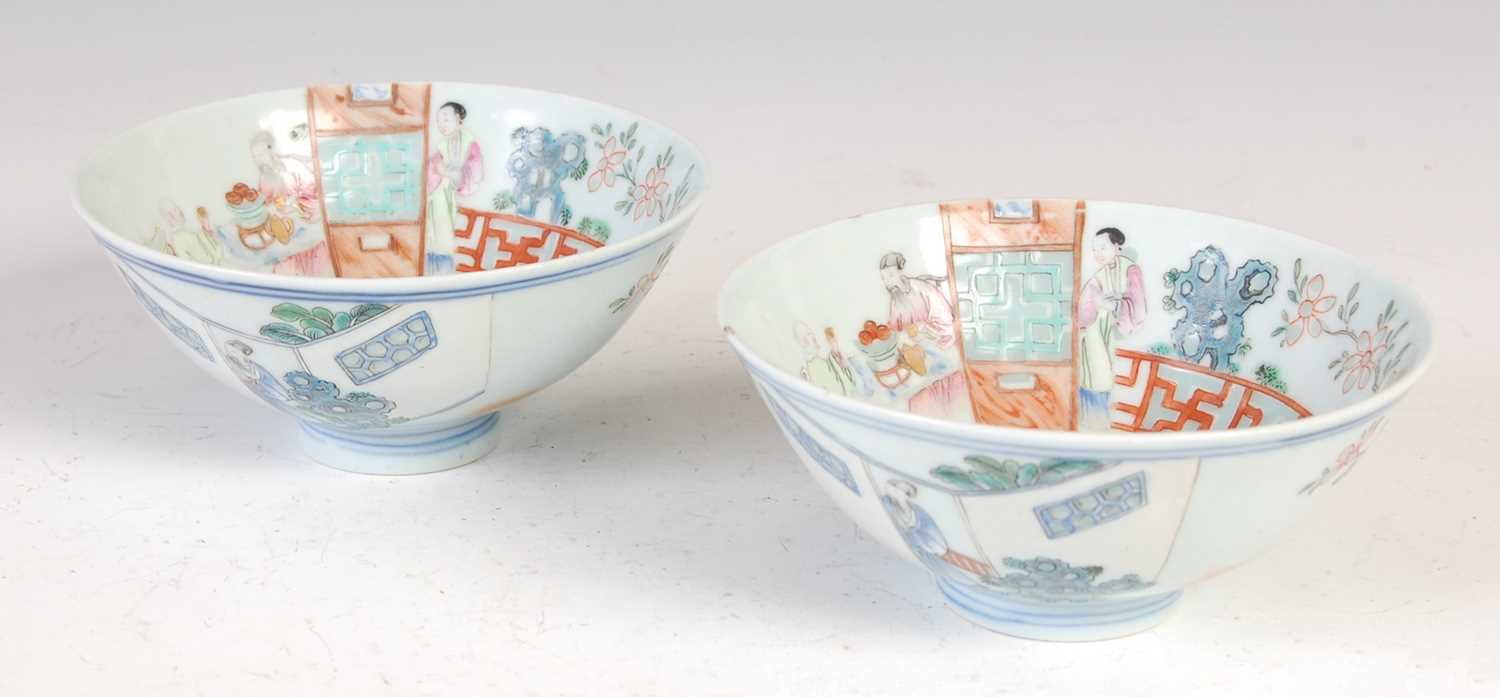 Lot 677 - A pair of Chinese porcelain famille rose footed bowls, Qing Dynasty, bearing Qianlong seal marks