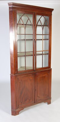 Lot 34 - A late George III mahogany two-part corner cupboard