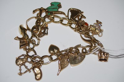 Lot 60 - A 9ct gold charm bracelet suspending eighteen...