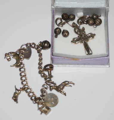 Lot 184 - A white metal charm bracelet suspending seven...