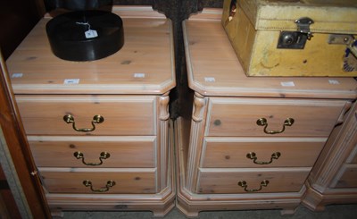 Lot 942 - A set of three limed pine bedside chests of...