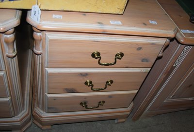 Lot 942 - A set of three limed pine bedside chests of...