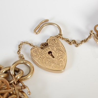 Lot 457 - A 9ct gold charm bracelet, suspending twenty...