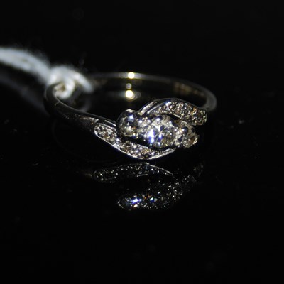Lot 75 - A white metal and diamond set three stone ring...