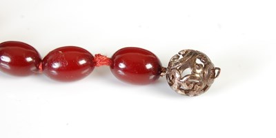 Lot 458 - A red amber type necklace, formed from a...