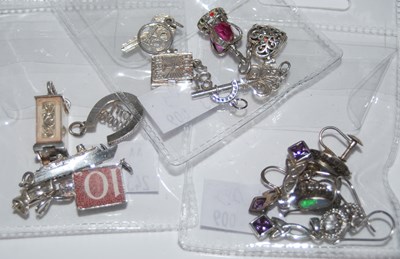 Lot 110 - A collection of assorted white metal charms...