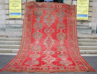 Lot 1054 - A late 19th century red ground Ushak carpet,...