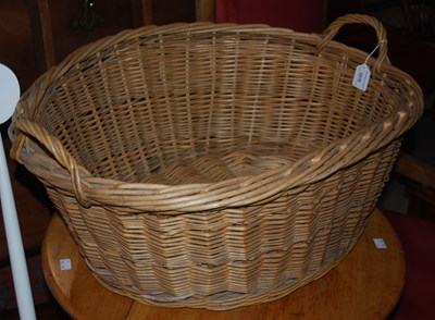 Lot 1019 - An oval wicker two handled basket, 70cm wide.