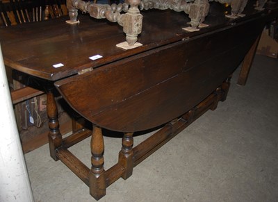 Lot 1024 - An antique oak wake table, the oval top with...
