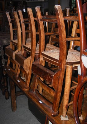 Lot 1027 - Six beechwood and rush seated cathedral chairs,...
