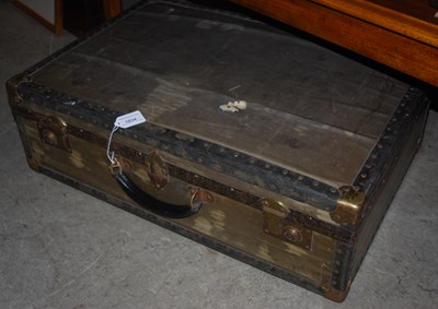 Lot 1034 - A vintage brass and metal bound suitcase.