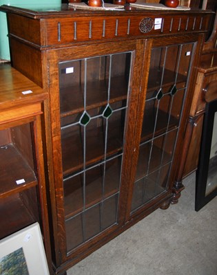 Lot 998 - An oak Arts and Crafts style bookcase with two...
