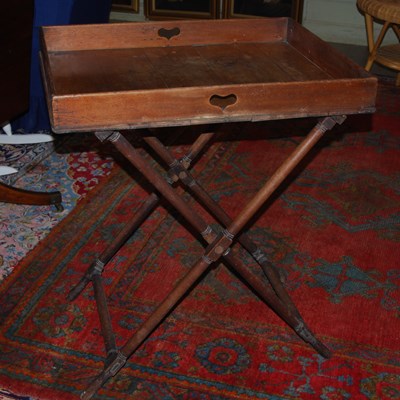 Lot 1047 - An antique mahogany butlers tray on stand,...