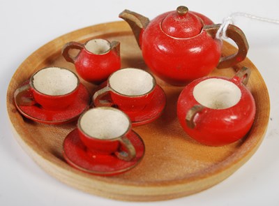 Lot 221 - A miniature carved and painted wood tea set...