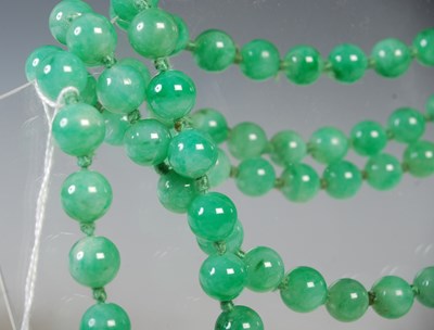 Lot 35 - A long green jade bead necklace, together with...