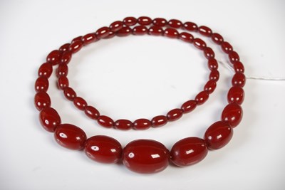 Lot 51 - A vintage red amber type graduated bead...