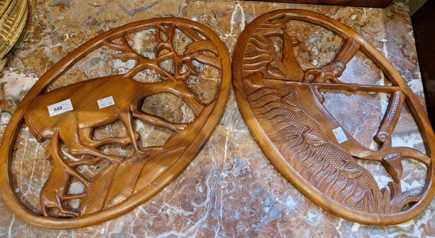 Lot 648 - Two teak carved wooden wall plaques, one in...