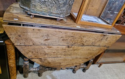 Lot 712 - A 19th century oak drop-leaf gate leg table.