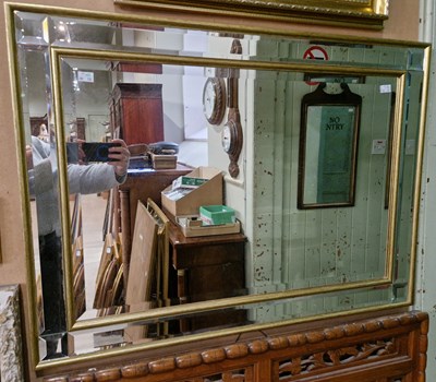 Lot 630 - A rectangular bevelled glass wall mirror...