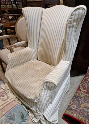 Lot 795 - An early 20th century wingback armchair with...