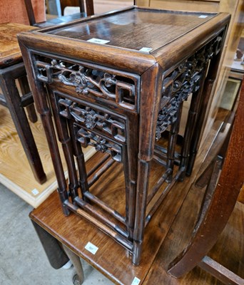 Lot 808 - A Chinese dark wood nest of three tables, late...