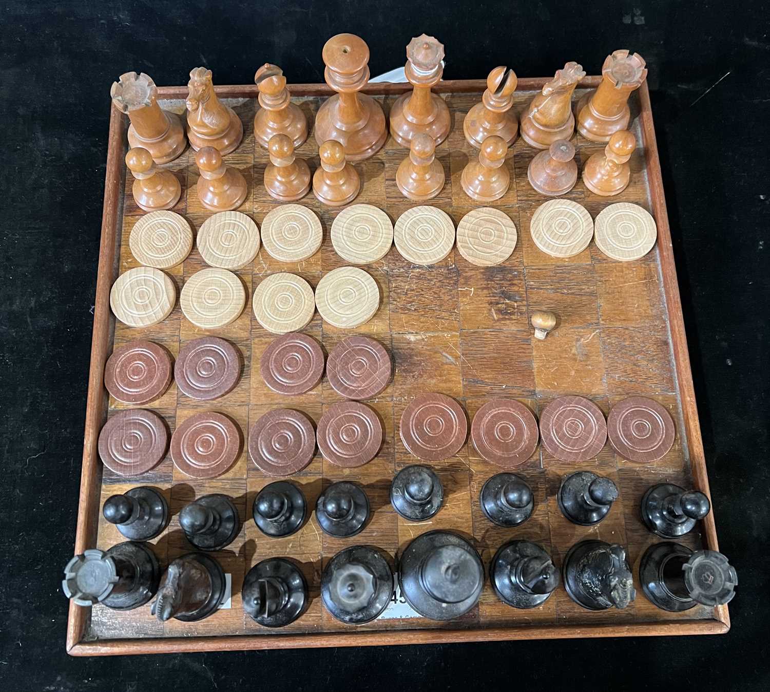Lot 245 - An early 20th century wooden draughts board...
