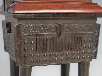 Lot 583 - A Chinese bronze archaic style Ding and wood...