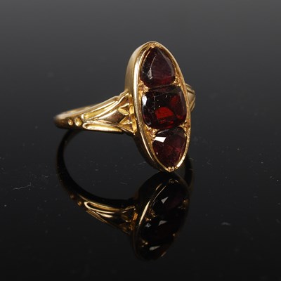Lot 63 - A yellow metal and garnet dress ring, set with...