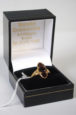 Lot 63 - A yellow metal and garnet dress ring, set with...