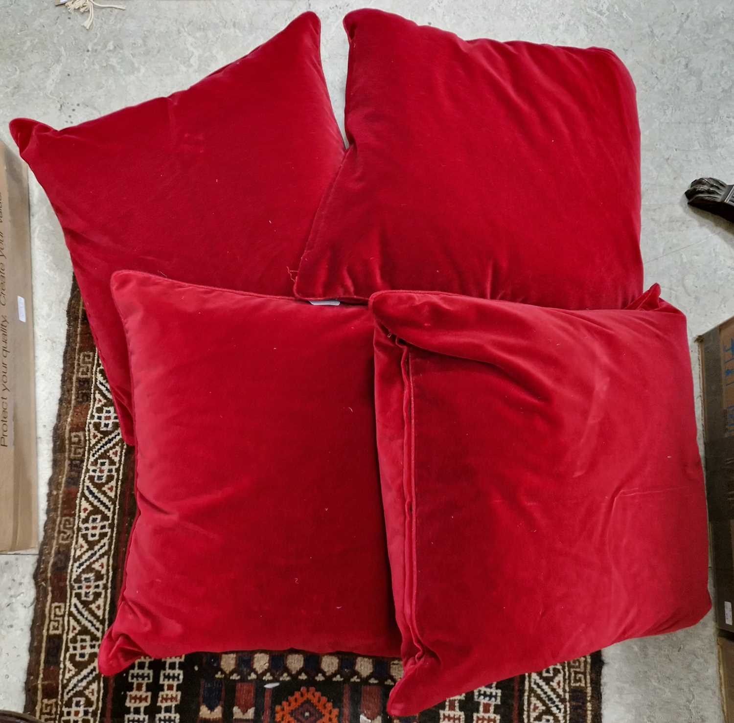 Lot 409 - Four Oka red velvet upholstered cushions.