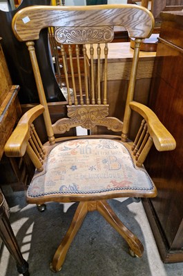 Lot 595 - A 20th century light oak revolving office...