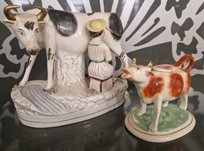 Lot 508 - A Staffordshire pottery cow creamer, together...