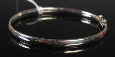 Lot 287 - A 9ct white gold hinged bangle, 19.7 grams.