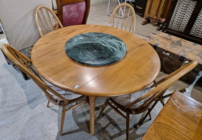 Lot 884 - An Ercol blonde wood dropleaf table and four...