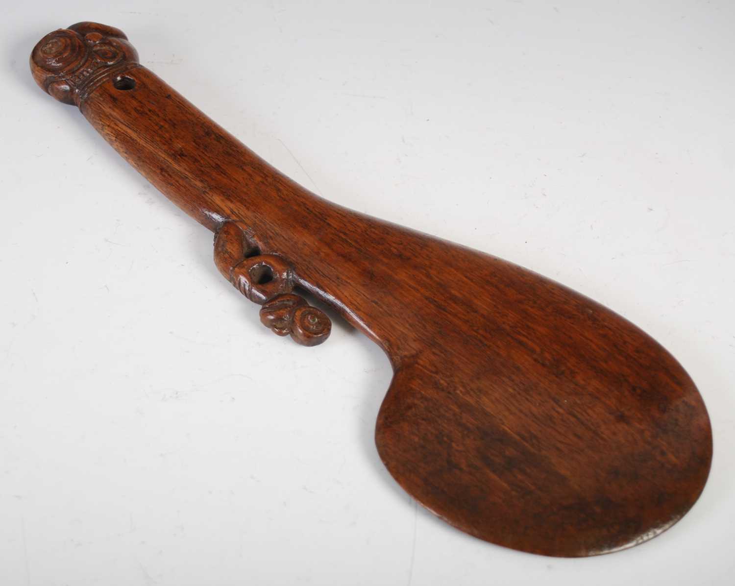 Lot 143 - A Māori wood Patu, carved with stylised figure...