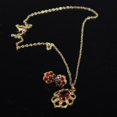 Lot 488 - A 9ct gold and garnet set pendant suspended on...