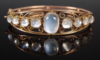 Lot 517 - A yellow metal and moonstone hinged bangle,...