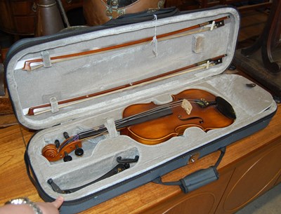 Lot 635 - A cased violin set comprising violin, two bows,...