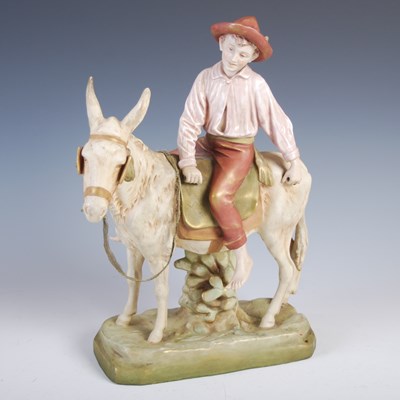 Lot 404 - A Royal Dux porcelain figure of a boy riding a...