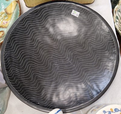 Lot 523 - A decorative pottery charger, the black ground...