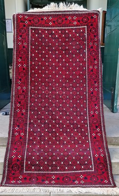 Lot 985 - An Iranian madder ground rug, the rectangular...