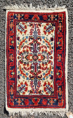 Lot 991 - A small Persian mat, the ivory ground...