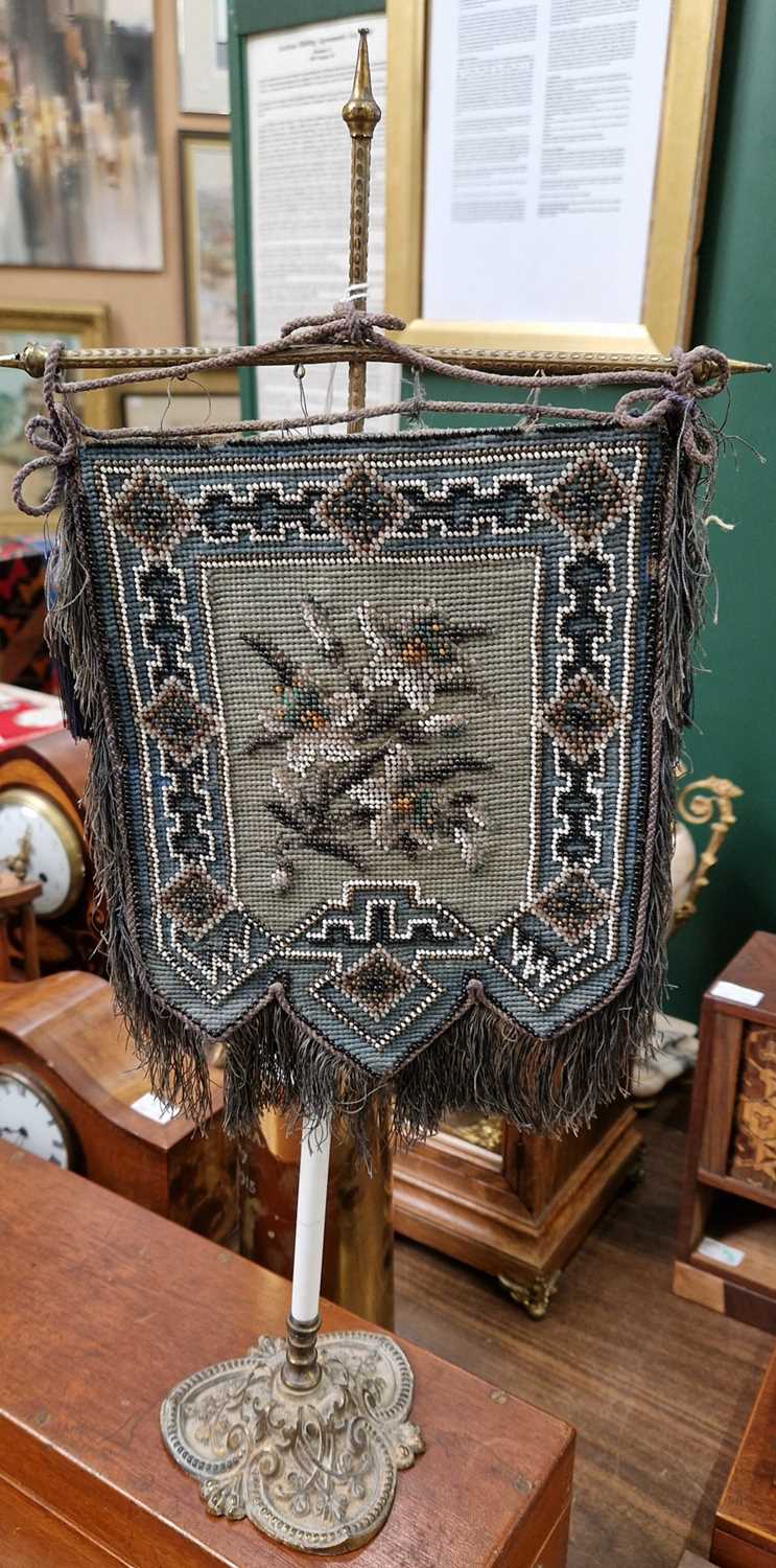 Lot 394 - An antique beadwork table screen centered with...