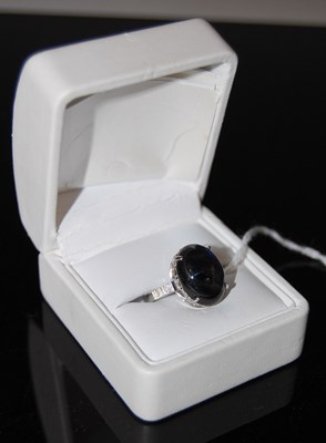 Lot 56 - A white metal and blue cabochon set ring.