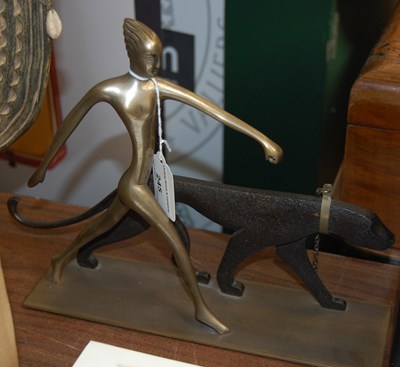 Lot 245 - An Art Deco figure of a woman walking a black...