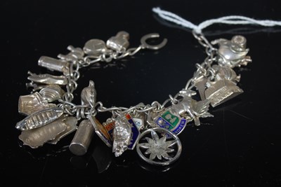 Lot 141 - A white metal charm bracelet suspending...
