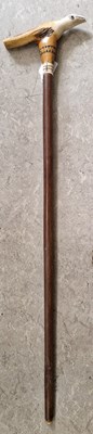 Lot 410 - A horn handled walking cane, the handle carved...